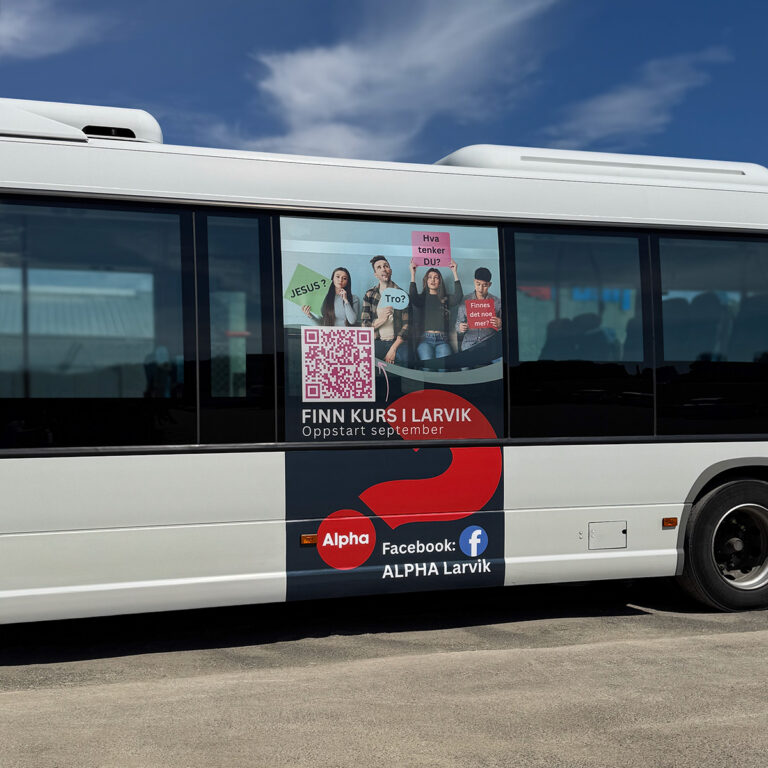 Hvit buss med stående reklame på siden for Alpha Larvik