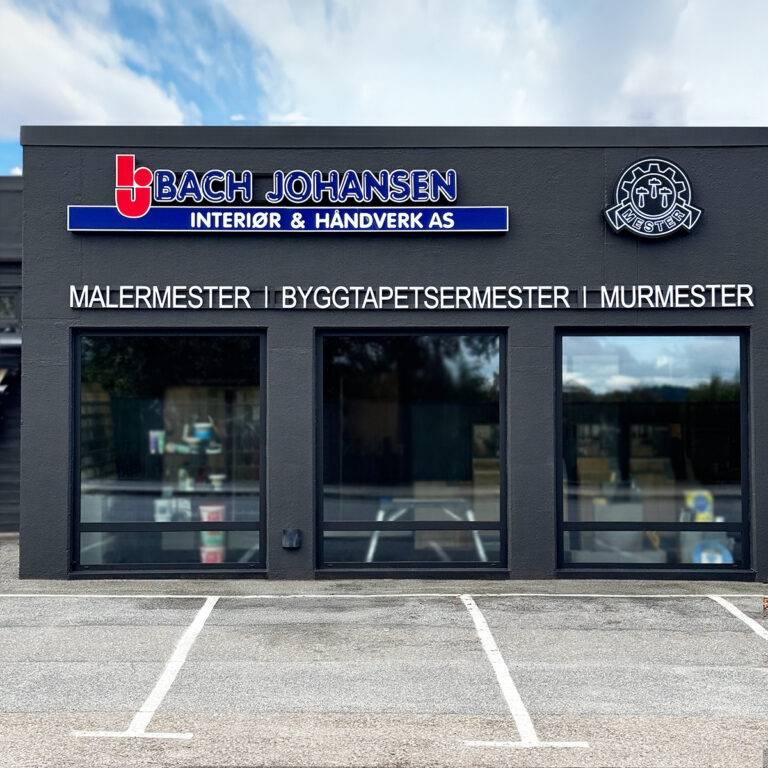 Tre LED-skilt, lysskilt på mørk grå fasade. Bach Johansen Interiør & Håndverk AS
