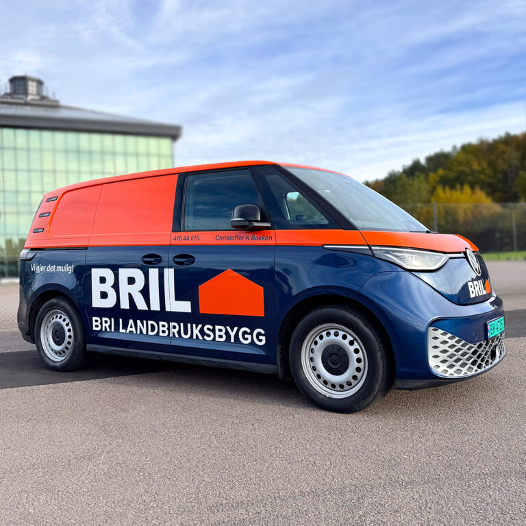 Helfoliert ID Buzz sett fra siden. To-farget med blått nederst og oransje øverst og stor BRI Landbuksbygg logo