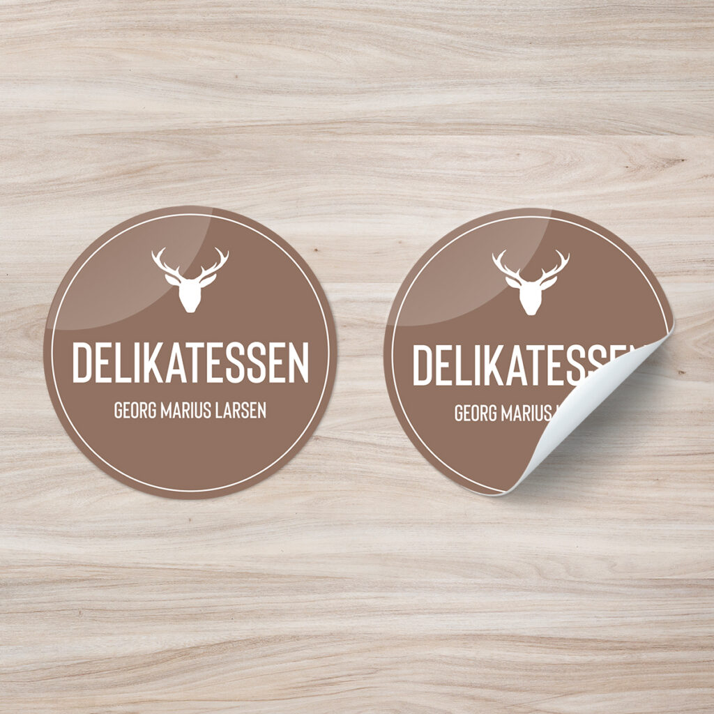 Klistremerker i brun utførelse med logo på treverk. Logo Delikatessen - Georg Marius Larsen