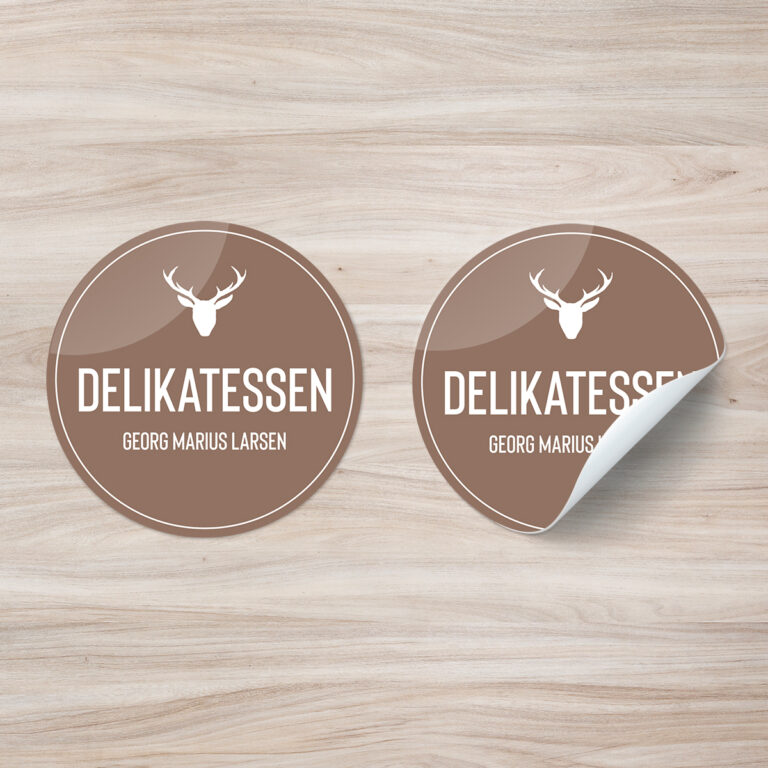 Klistremerker i brun utførelse med logo på treverk. Logo Delikatessen - Georg Marius Larsen
