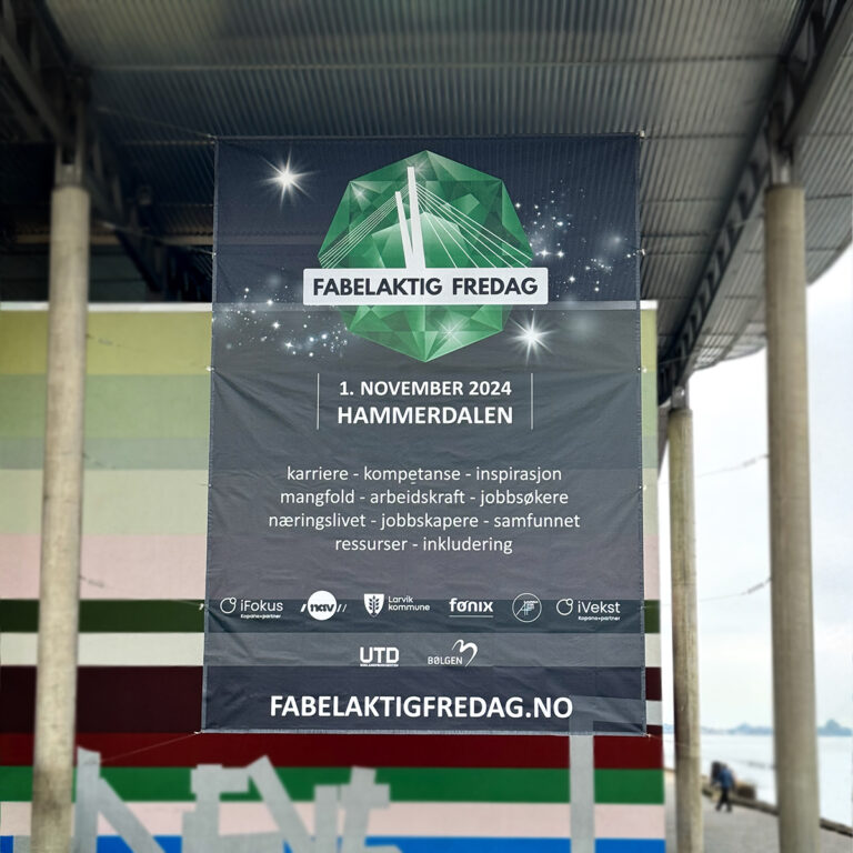 Stor sort banner i mesh for Fabelaktig Fredag som henger på Bølgen Kulturhus i Larvik.