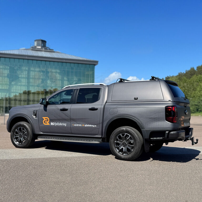 Helfoliert pickup sett fra siden. Foliert med printet wrappingfolie i grå med ton-i-ton detaljer og RG Fjellsikring logo