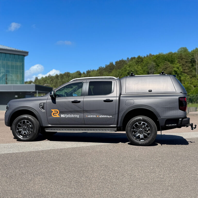 Pickup med kasse på lasteplanet sett fra siden - helfoliert i grått med ton-i-ton detaljer og RG Fjellsikring logo på siden