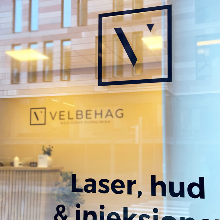 Nærbilde av utskåret folie på glass for Velbehag Medisinsk hudklinikk