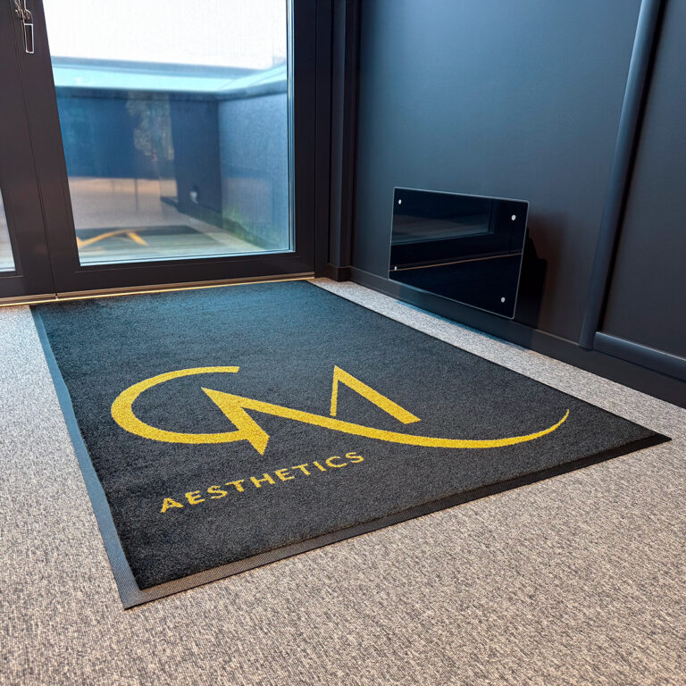 Nærbilde av stor dørmatte med logo - GM Aesthetics