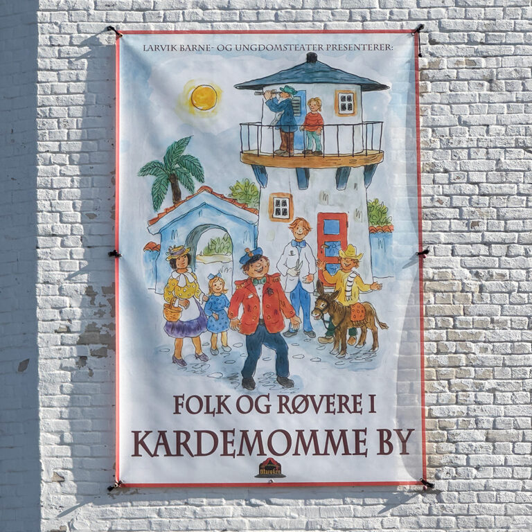 Nærbilde av banner i mesh som henger på fasaden til Teaterhuset Munken