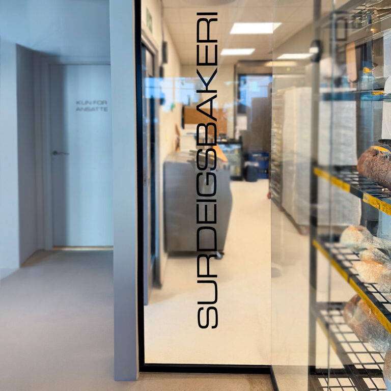 Nærbilde av utskåret sort folie på glass for Majas Surdeigsbakeri