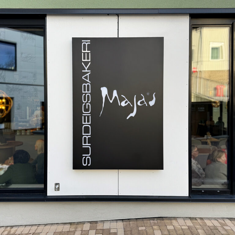 Sort LED-skilt med hvite akrylbelyste bokstaver for Majas Surdeigsbakeri