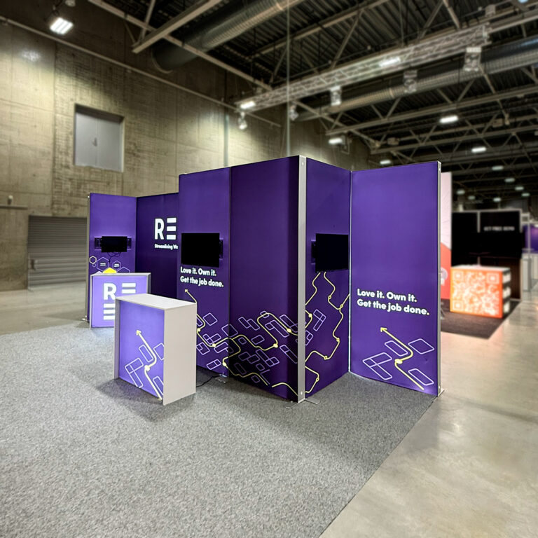 Messestand med lilla tema. Lyskasser og messebord satt sammen til en stand for Reen