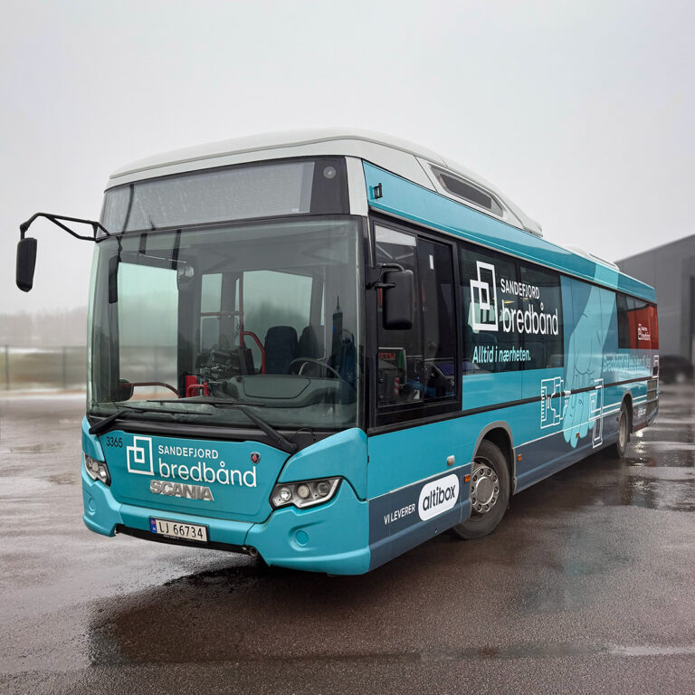 Helfoliert blå buss sett forfra med bussreklame for Sandefjord Bredbånd