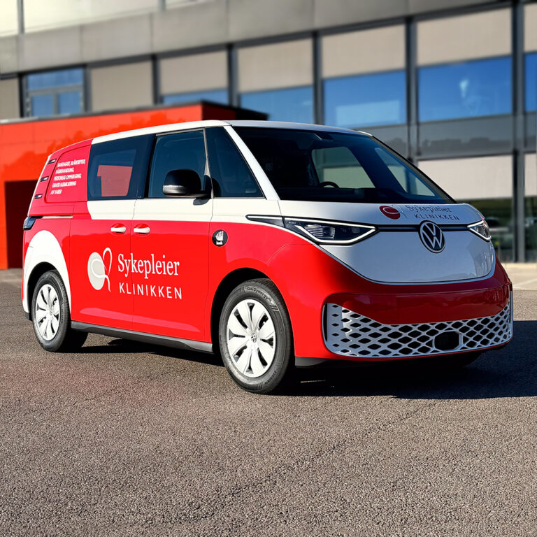 Halvfoliert ID Buzz med rød wrappingfolie og logo for Sykepleierklinikken