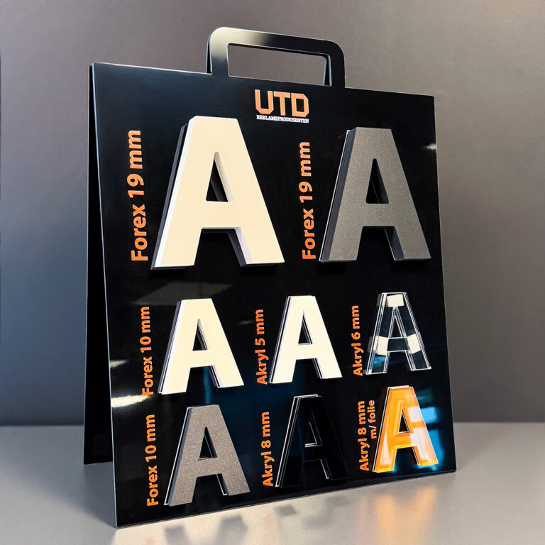 Nærbilde av materialdisplay i sort med bokstaver i ulike materialer for UTD Reklameprodusenten