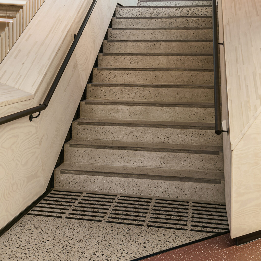 Taktil merking i bunnen av en trapp for å markere for svaksynte på Høyskolen i Kristiania