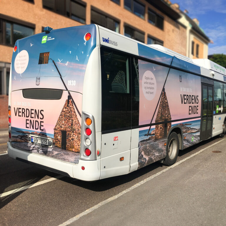 Buss i trafikken med foliert bussreklame for Verdens Ende.