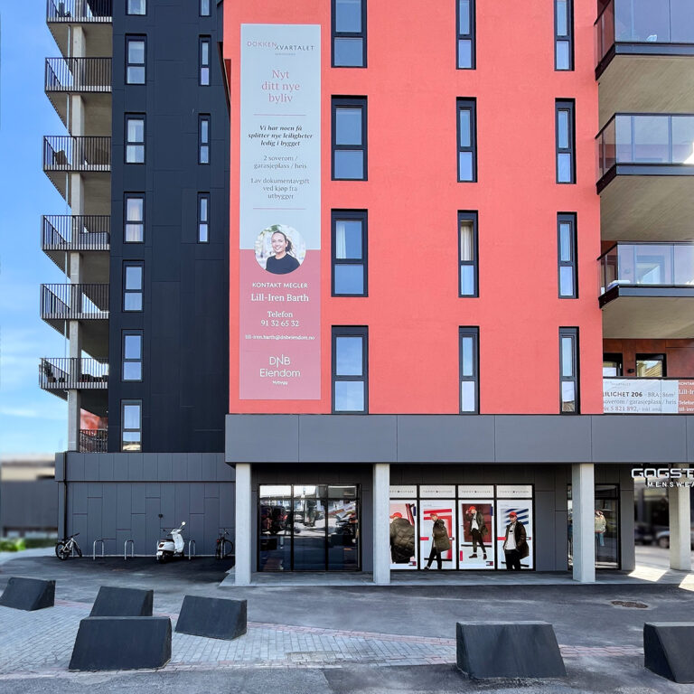 Stort stående skilt på fasaden til en boligblokk i Sandefjord for DNB Eiendom