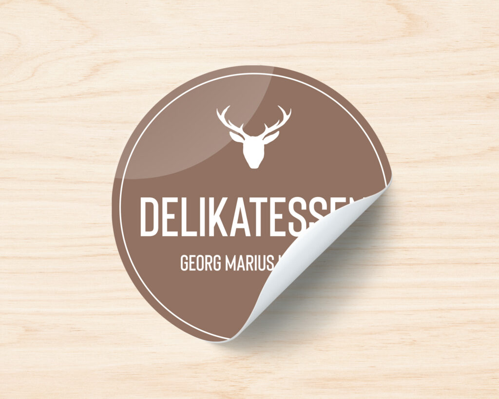 Klistremerker i brun utførelse med logo på treverk. Logo Delikatessen - Georg Marius Larsen