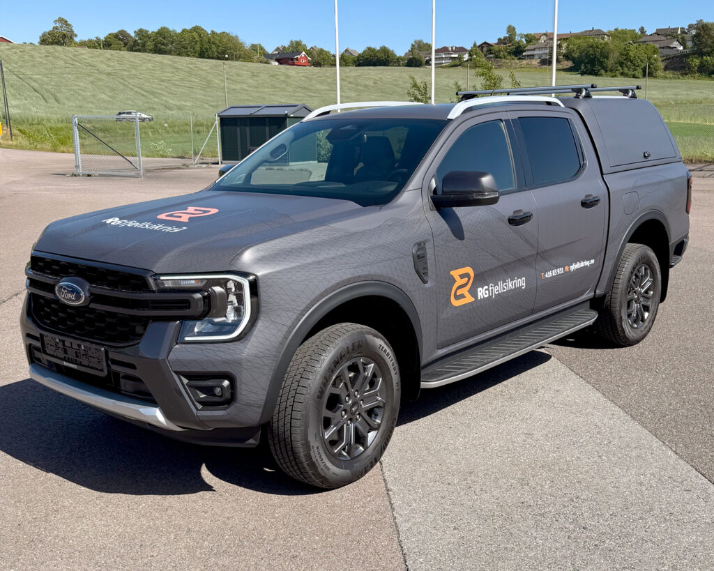 Helfoliert varebil for RG Fjellsikring i matt grå satin utførelse med logodetaljer ton-i-ton grå, hvit og oransje.