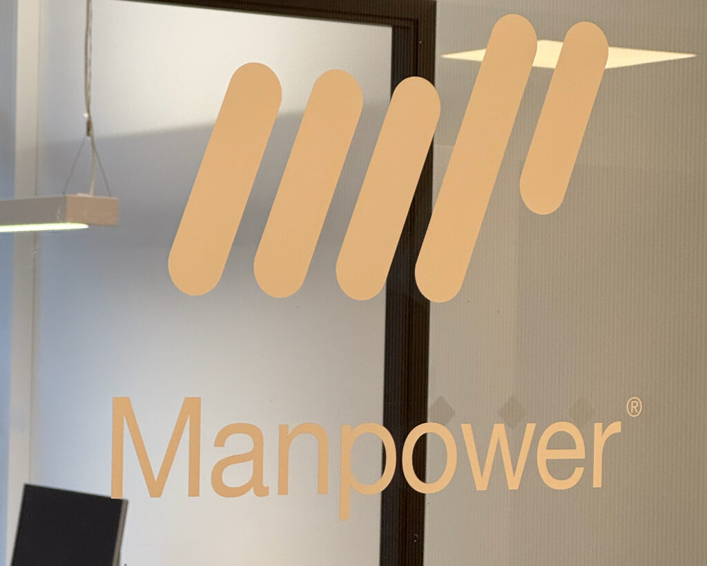 Utskåret folie logo for Manpower montert på glass i kontolokaler
