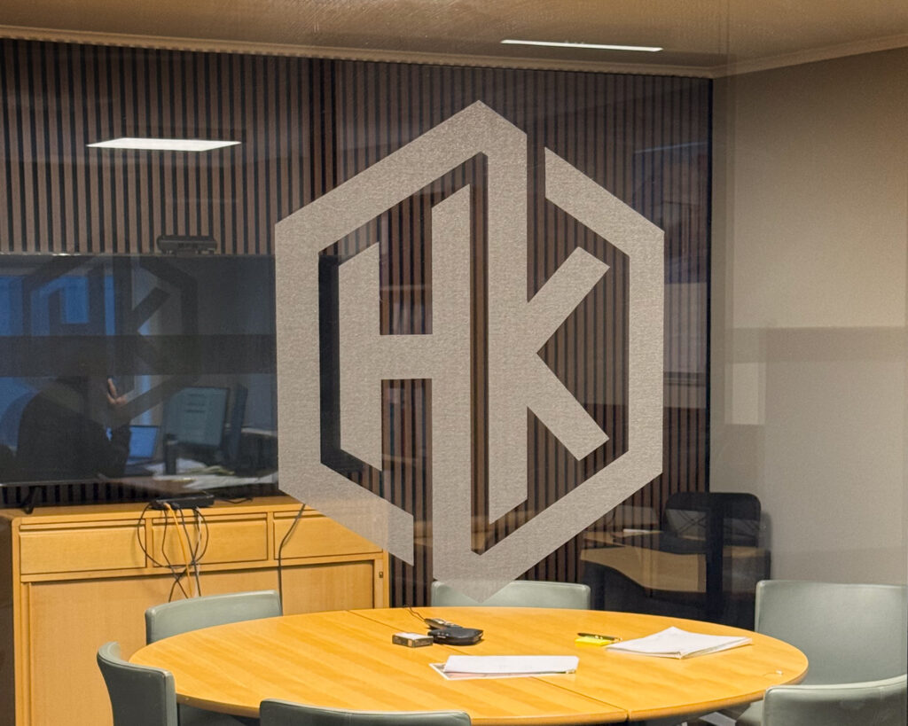 Utskåret logo i frostet folie HK i kontorlokaler og møterom.
