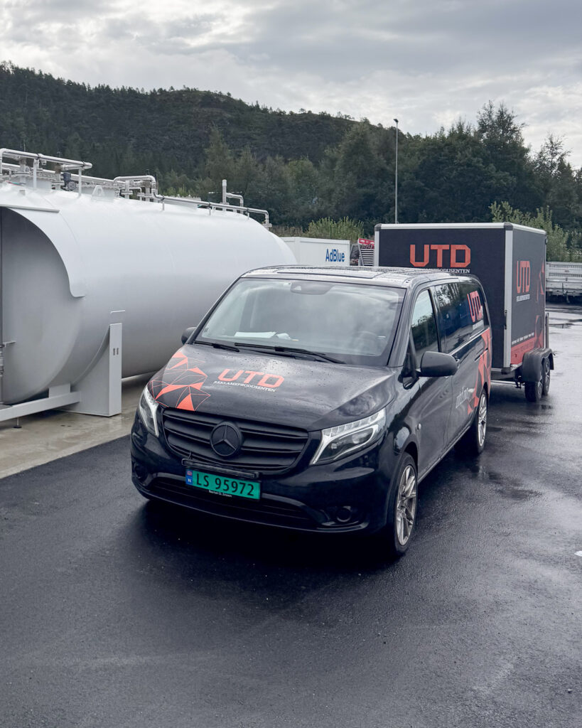 UTD Reklameprodusenten montasjebil og henger parkert ved Esso Energi pumpestasjon under montering i Midt-Norge