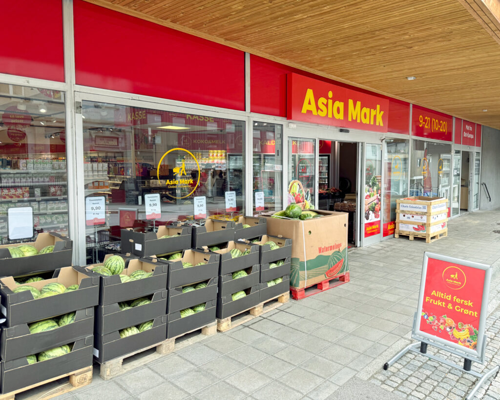Asia Mark-fasade med rød skilting og gul tekst, åpen butikk med frukt og grønt utenfor — butikkprofilering Larvik