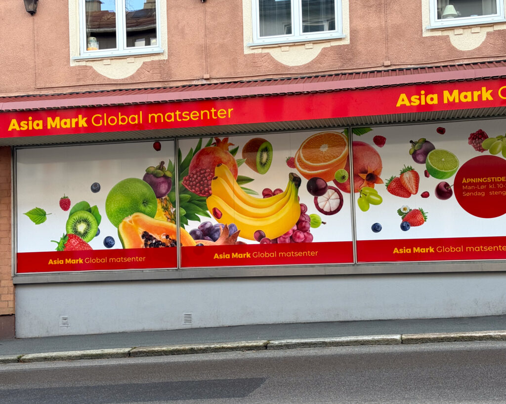 Vindusdekor på Asia Mark med fruktgrafikk og profiltext — foliedekor produsert av UTD Reklameprodusenten